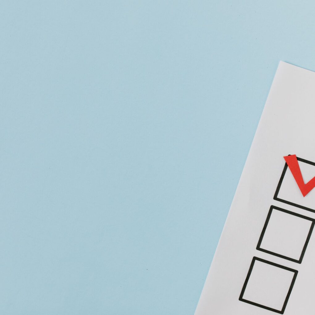 A checklist with a red checkmark to denote a completed task on a pastel blue background.